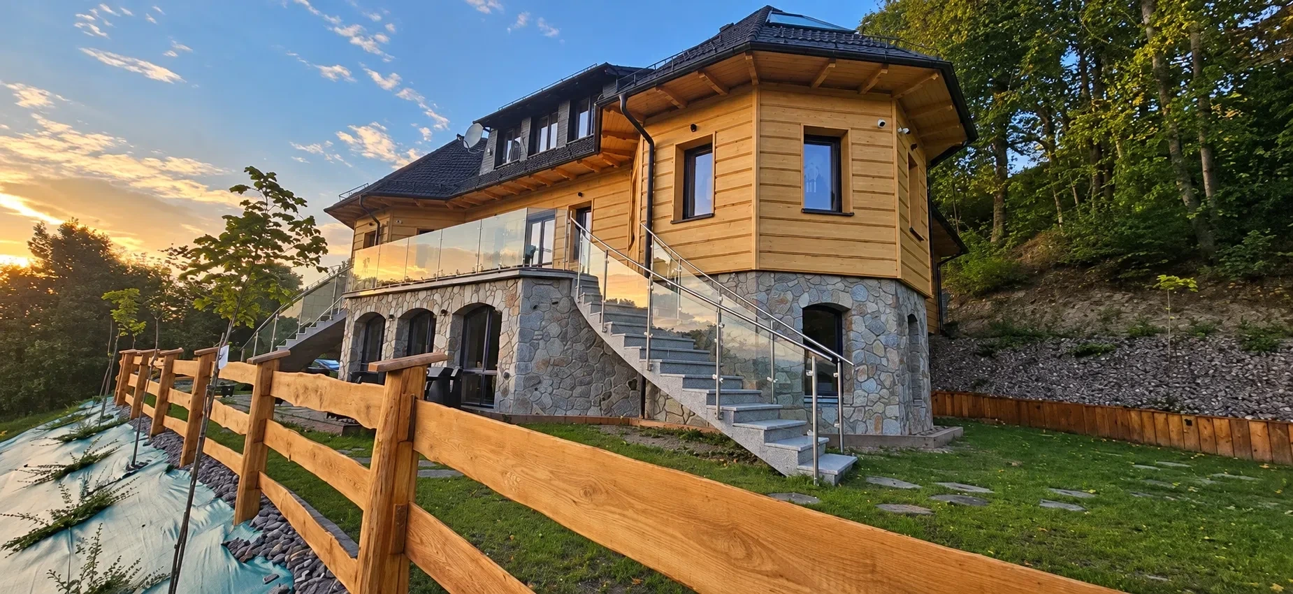 Villa na Pagórku — drewniano-kamienny budynek z tarasem i schodami na zboczu, otoczony lasem